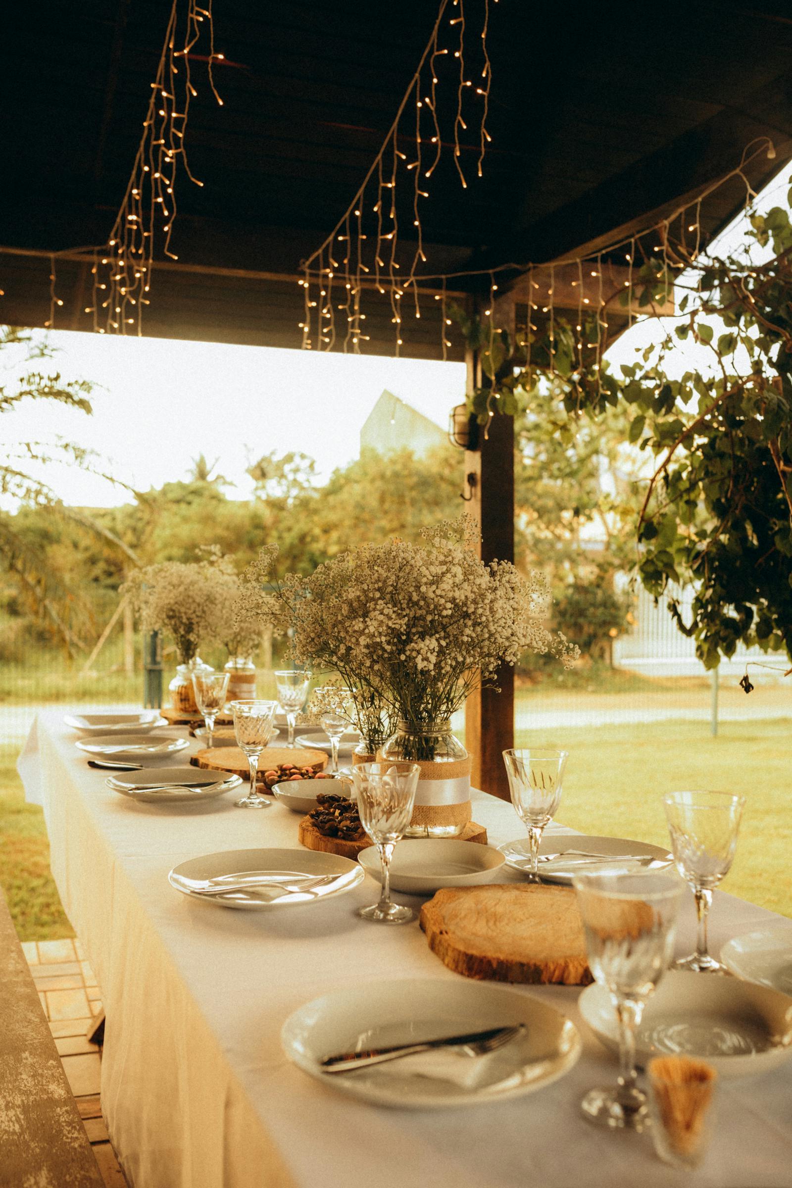 A long shaded terrace with linen-covered tables overlooking the Andes — late afternoon light on the vines.