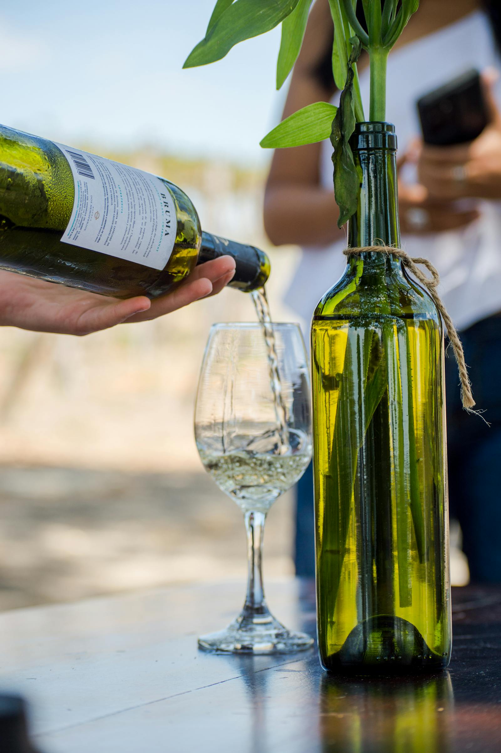 Vermora estate Chardonnay — a pale gold glass against the cellar wall.