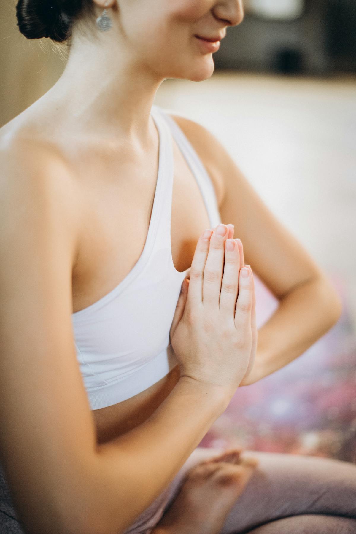 Pranayama class — student seated cross-legged with hands on knees, eyes closed, in a quiet morning practice.